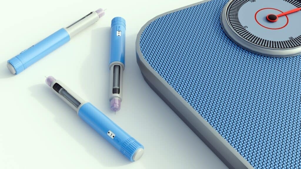 GLP-1 medication side effects explained — injection pens and weight scale used in medical weight loss treatment