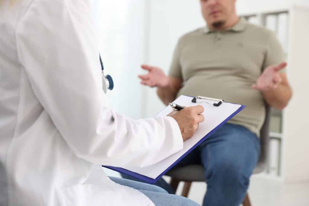 Overweight man discussing trt and medical weight loss options with provider during clinical consultation